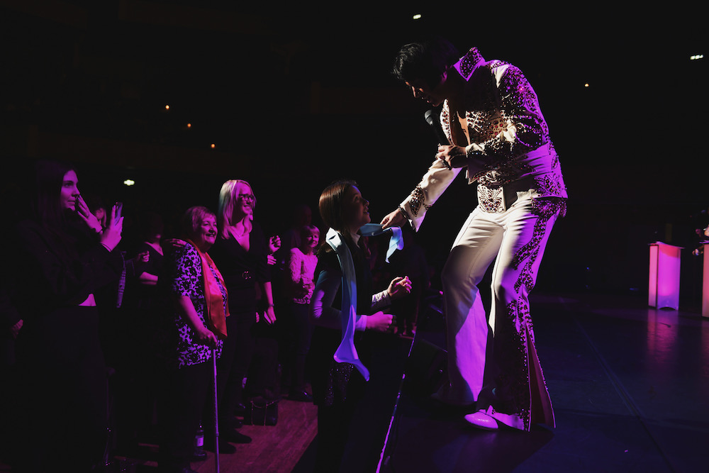 Rob Kingsley performing A Vision of Elvis live on stage in the Stone and Flame Elvis suit greeting fans at the front of the stage